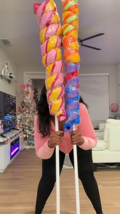 a woman holding two giant candy lollipops in her hands