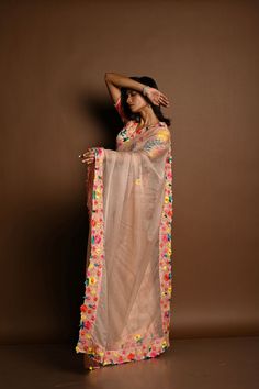 This elegant organza saree in coral peach features exquisite multicolored floral hand embroidery. Paired with a stitched, padded blouse with elbow-length sleeves and a V-neckline, it’s the perfect blend of timeless beauty and sophistication. Peach Organza Saree, Organza Sari, Baluchari Saree, Floral Hand Embroidery, Hand Embroidery Work, Silver Blouse, Orange Saree, Cotton Gowns, Padded Blouse