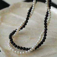 Material: black agate/freshwater pearl + 18K gold plating Experience the timeless contrast between black onyx and white pearls with this simple yet striking design. Natural pearls add a soft beauty, while black agate adds a unique charm. This necklace can be DIY by yourself. The two beads are scattered and have a sense of hierarchy. They are twisted together and have a sense of design.But you can't take it apart and wear it alone~ Module description placeholder text Elegant Black Pearl Necklace With Charm, Elegant Black Beaded Necklace With Pearl Charm, Black Pearl Necklaces With Pearl Charm, Black Beaded Pearl Necklaces With Pearl Charm, Black Pearl Pendant Beaded Necklace, Black Beaded Pearl Necklaces With Pearl Pendant, Black Beaded Necklaces With Pearl Chain For Gift, Black Beaded Pearl Chain Necklace As Gift, Black Beaded Pearl Chain Necklace For Gift