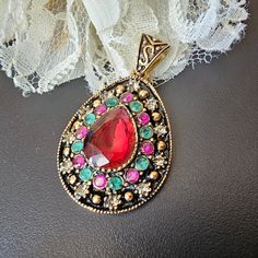 Byzantine Style Golden Brass Pendant Ruby Emerald Setting Finish 45x25mm. The emeralds and rubies (small) are natural, the central garnet cabochon must be synthetic and the entourage is set with zircons   I try to describe my items as well as possible and the photos are part of the description. Please ask any questions you may have before purchasing. As Yvonne & Magaly antique jewelry is on sale on other media, it can be withdrawn from sale at any time. If exceptionally the object does not corre Ornate Jeweled Pendant Jewelry, Ruby Cabochon Pendant Jewelry, Ornate Pendant Jewelry With Stone Setting, Ornate Pendant With Stone Setting, Red Byzantine Jewelry As Gift, Red Byzantine Jewelry Gift, Red Byzantine Style Jewelry Gift, Ruby Emerald, Brass Pendant