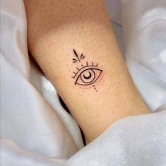 an eye tattoo on the leg is shown in black ink, with dots around it