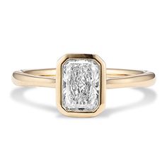 a yellow gold ring with a square cut diamond