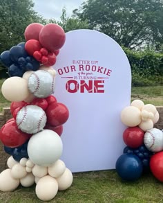 an arch made out of balloons with the words our rookie is in red, white and blue