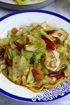 a white plate topped with cabbage and red peppers