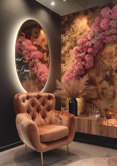 a fancy chair in front of a mirror with pink flowers on the wall behind it