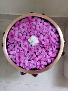 pink flowers floating in a bowl on the floor