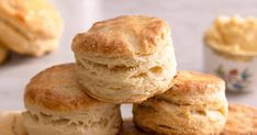 three biscuits stacked on top of each other next to some cupcakes and butter