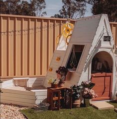 a house shaped like a doghouse with a ladder leading up to it's door