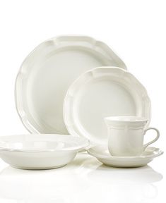 white dishes and cups are stacked on top of each other