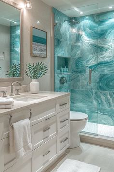 a bathroom with a glass shower door and marble counter tops