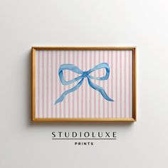 a painting with a blue bow hanging on it's wall above the words studioluxe prints