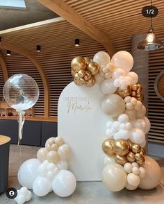 balloon arch with gold and white balloons on it