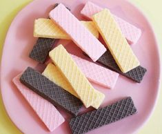 some waffles are on a pink plate with yellow and black squares around them