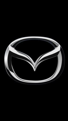 the front end of a silver mazda logo on a black background with no image to describe