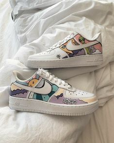 the nike air force is decorated with cartoon characters and clouds on white shoes, while sitting on a bed