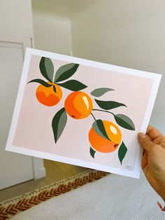 a person holding up a card with oranges on it