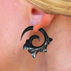 a close up of a woman's ear with an artistic design on the side