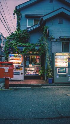 an advertisement for tokyo night in front of a blue building with plants growing on it