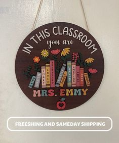 a wooden sign that says in this classroom you are mrs - emy and flowers