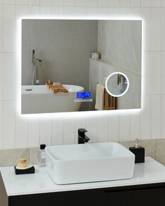 a bathroom with a sink, mirror and soap dispenser on the counter