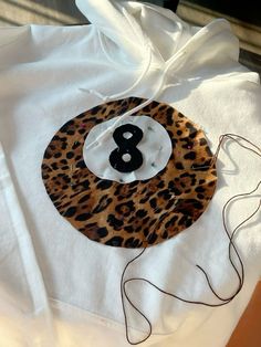 a white hoodie with an animal print number eight on it