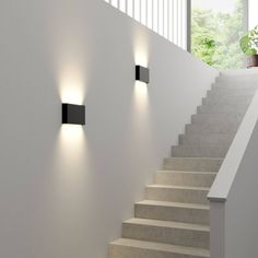 three lights are on the wall above some stairs