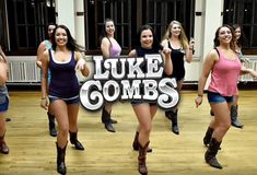 a group of young women dancing in a dance studio with the words luke combs