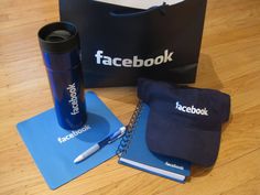 a notebook, pen and hat sitting on top of a wooden floor next to a bag