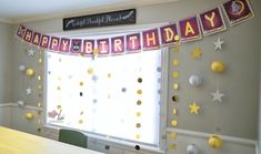 a birthday banner is hanging in front of a window