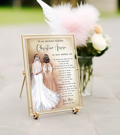 a memorial plaque with two brides on it next to a vase filled with flowers