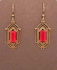 Ruby Red Crystal Art Deco Earrings have an antique brass base which is a metal stamping with hollow back. Centered large rectangular vintage crystal chaton with gold back. Earrings dangle from antique brass tone ear wires. These are Takeen Arts original and one-of-a-kind (OOAK). Designed and created by TLP and staff for Takeen Arts. Item E841. Formal Red Brass Earrings, Vintage Rectangular Metal Earrings, Art Deco Red Rectangular Jewelry, Red Rectangular Art Deco Jewelry, Vintage Red Brass Earrings, Red Art Deco, Deco Earrings, Red Art, Art Deco Earrings