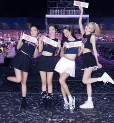 the girls are posing with their signs in front of an audience at a concert or show