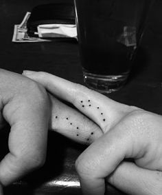 two people holding hands with small tattoos on their fingers and the words, big dipper little dipper tattoos