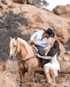 a man riding on the back of a brown horse next to a woman