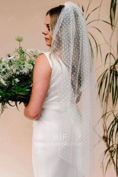 a woman wearing a veil and holding a bouquet