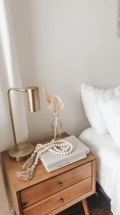 a bedroom with a bed, nightstand and lamp on top of the night stand in front of the bed