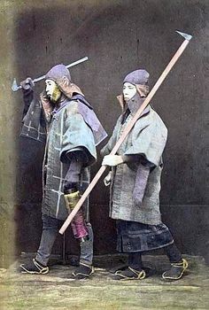 an old photo of two people dressed in medieval garb and holding spears, standing next to each other