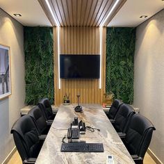 a conference room with black leather chairs and a flat screen tv mounted on the wall