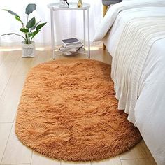 a bed room with a neatly made bed and a large rug on the floor next to it