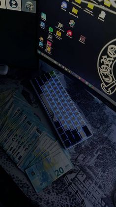 a computer keyboard sitting on top of a desk next to some paper money and a mouse