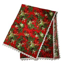 two red and green christmas napkins with pom poms on them, one has holly