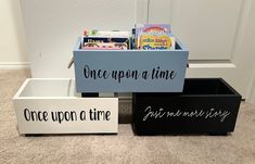 three bins that have books in them on the floor next to each other with words written on them