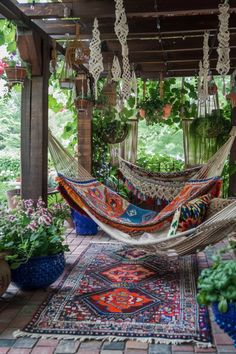 a hammock hanging from a pergolated area with potted plants in the background