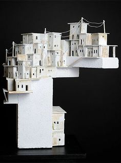 a model of a city made out of white blocks and wires on a black background