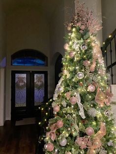 a christmas tree is decorated with pink and silver ornaments