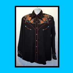 Vintage reproduction 1950s sequin western shirt Available in size large. The western shirt is a jet black rayon blend with contrasting brown piping on collar, front & back panels pockets. button down front and cuffs. The shirt has a seven brown pearl snap button down front and six matching button cuff. The shirt features embroidered images of hats, boots & guitars with clear, blue & red rhinestones. The label states Scully since 1904. 65% poly 35% rayon machine was cold with like col Thermal Shirt, Red Embroidery, Red Rhinestone, Western Shirts, 1950s Vintage, Puma Jacket, Western Fashion, Cotton Shirt, Cool Shirts