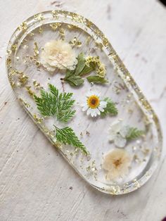 a glass tray with flowers and leaves on it