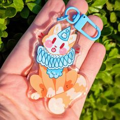 a hand holding a plastic keychain with an image of a cat on it