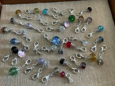 a box filled with lots of different colored glass beads and silver chain necklaces on top of a table