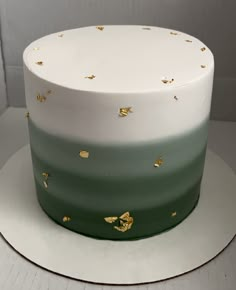 a white and green cake with gold stars on it